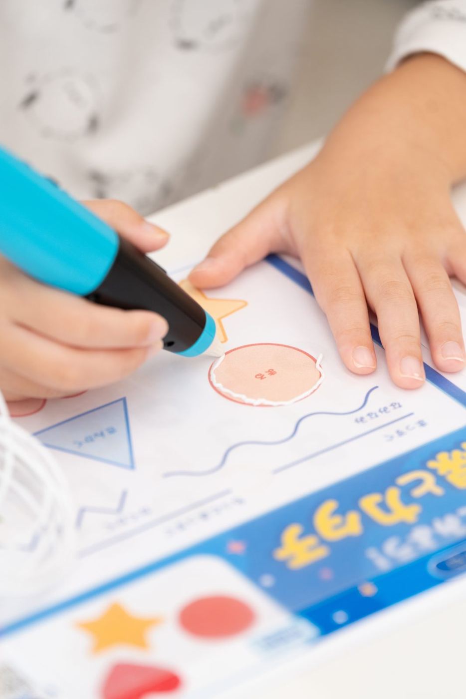 ペンを持つ手元と、図案をなぞる様子